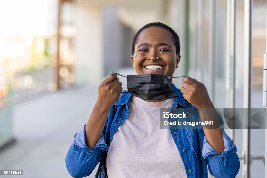 Woman wear with protective face mask Masked woman - protection against influenza virus. African - American woman wearing mask for protect. Woman wear with protective face mask. Stop the virus and epidemic diseases. Protective Face Mask Stock Photo