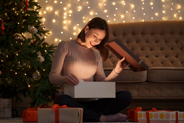 Happy beautiful woman opening a gift