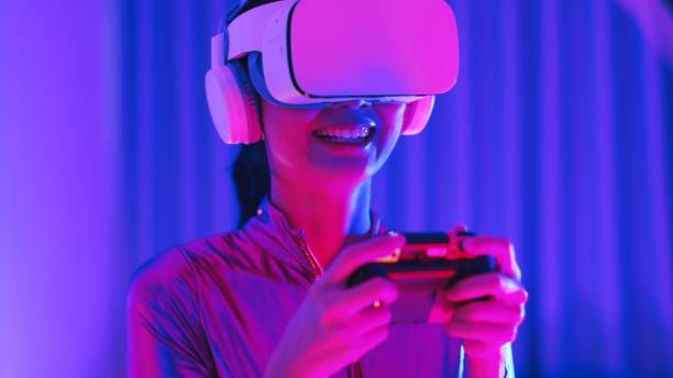 istock Young asian woman is using virtual reality headset. Neon light studio portrait. Concept of virtual reality, simulation, gaming and future technology.Asian woman play game in bedroom. 1344387858