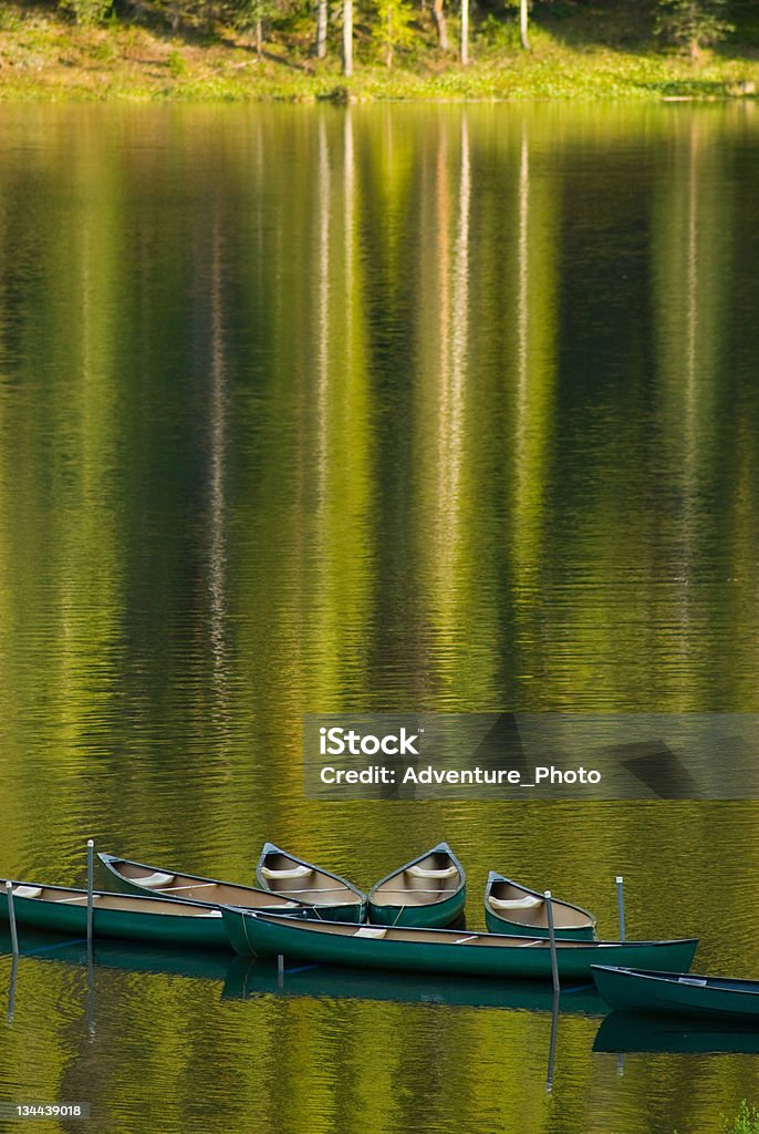 Reflection of Canoes on a Pristine Calm Lake at Sunset Canoeing on a Pristine Calm Lake Camping Stock Photo