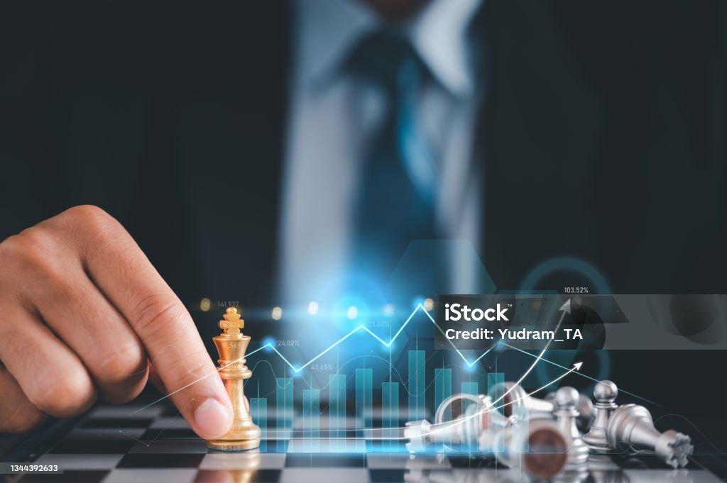 Businessman in black suite sitting player chess.meaning of planning and strategy ecision achievement goal concept of business. Strategy Stock Photo