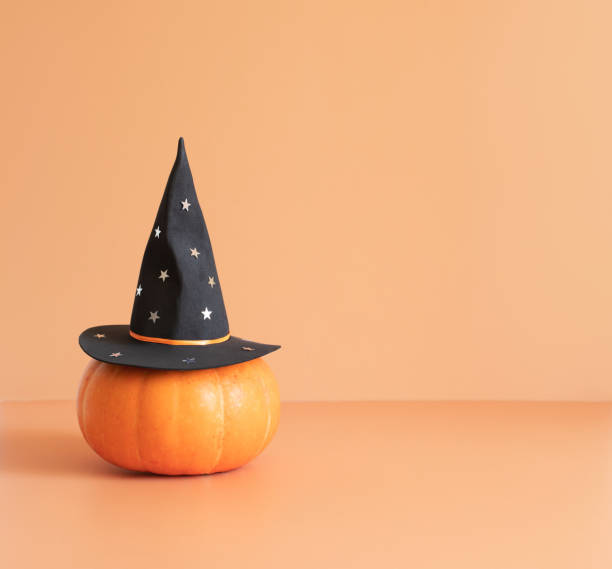istock Halloween pumpkin in a black witch hat on a beige background. Halloween minimal concept. Space for text. 1344403831