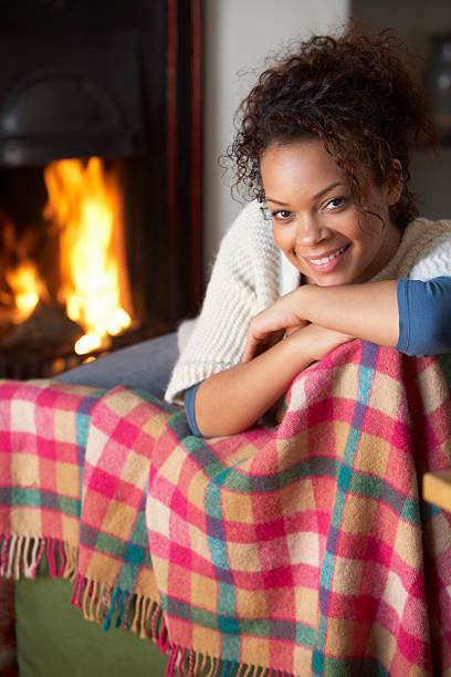 istock A young woman sitting in front of a fireplace 134440498