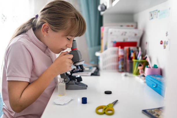 istock little girl examining and studying with microscope at home 1344404987