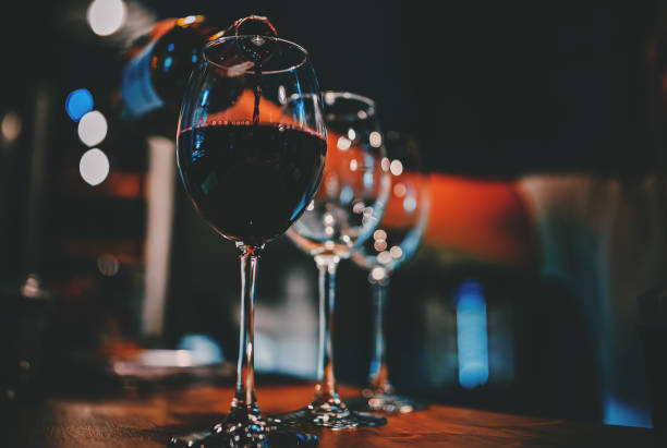 istock bartender pouring red wine into a glass in cafe or bar 1344407038
