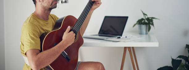 istock Man playing acoustic guitar at home. 1344409296