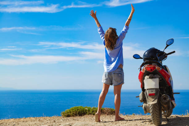 istock Woman with scooter looking at the distant sea horizon. 1344409463