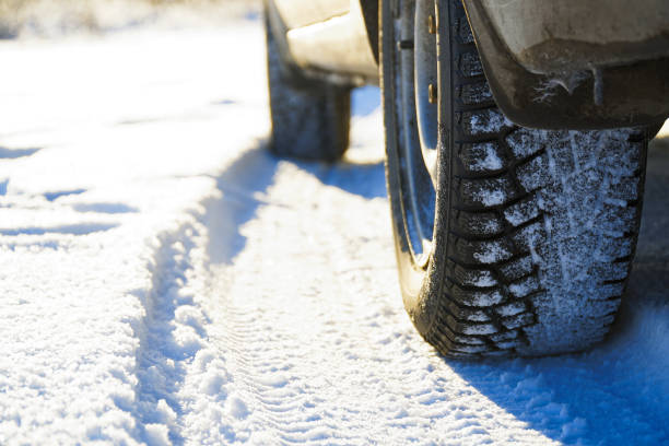 Studded winter car tires on snow-covered road