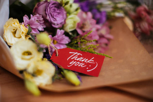 A colorful bouquet of flowers with a thank you note wrapped in gift wrapping paper