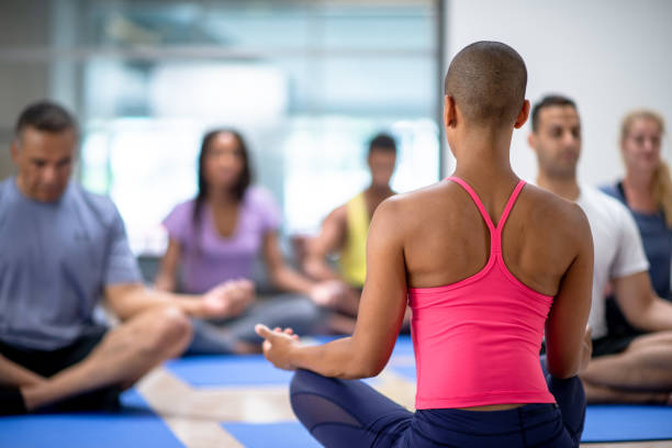Meditating together. Beautiful young women in sports clothing while sitting at lotus position.