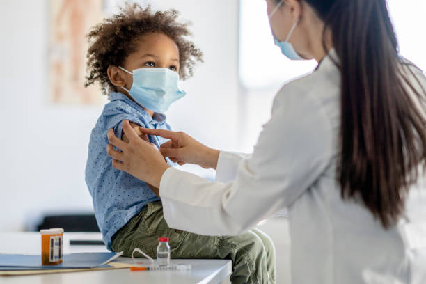 junge erhält während einer pandemie eine impfung - kleinstkind stock-fotos und bilder