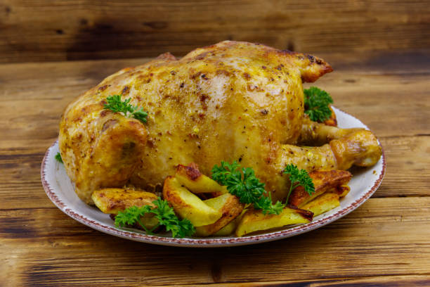 istock Baked whole chicken with potato on a wooden table 1344413258