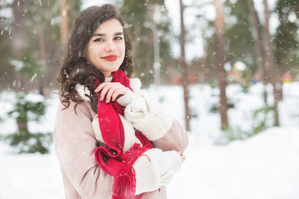 istock Pretty lady walking in the forest during snowfall 1344413326