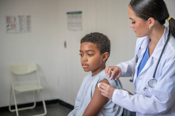 istock Doctor Disinfecting Injection Site on a Young Boy 1344413389