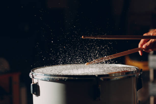 istock Drum sticks drumming beat rhythm on drum surface with splash water drops 1344415203