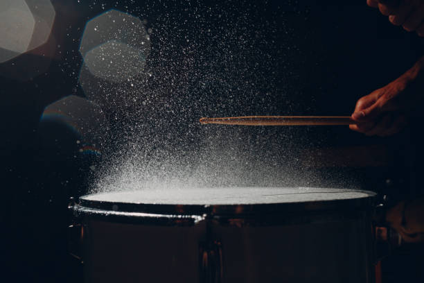 istock Drum sticks drumming beat rhythm on drum surface with splash water drops 1344415204