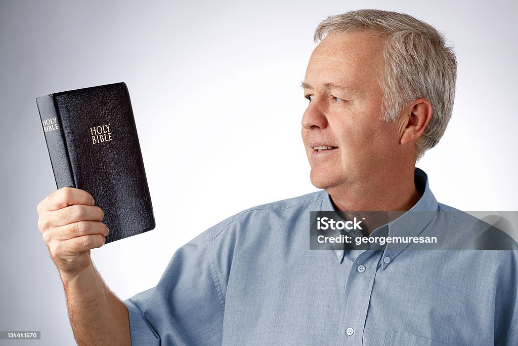 Give light to my eyes, Lord... Man looking to the Bible in his hand (Open my eyes that I may see wonderful things in your law Psalm 119.18) Active Seniors Stock Photo