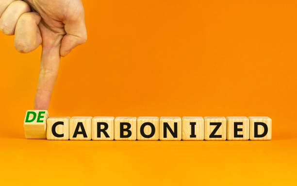 istock Carbonized or decarbonized symbol. Businessman turns a wooden cube and changes words 'carbonized' to 'decarbonized'. Orange background, copy space. Business, Carbonized or decarbonized concept. 1344417390