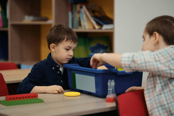 istock Two boys kids of different age playing with robot toy at school robotics class 1344422023