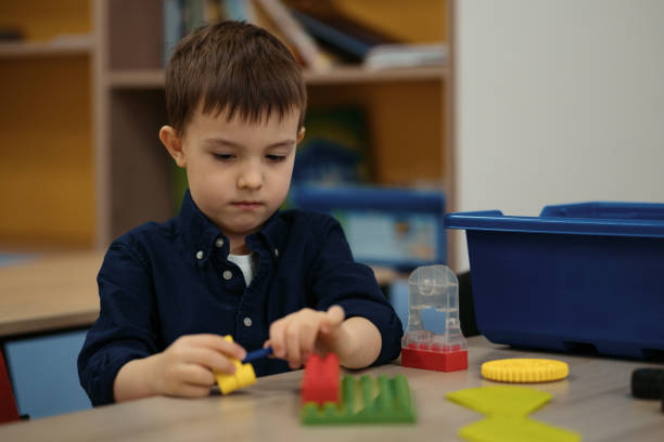 istock Little kid boy having fun with building and creating robot. 1344422067