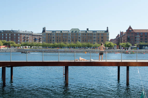 Copenhagen, Denmark - 02 Sep 2021: Young people sunbathing in the city centre, at Kalvebod Wave, Kalvebod Brygge