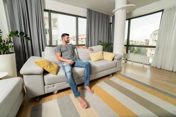 istock Handsome young man relaxing on sofa at his apartment. 1344424921