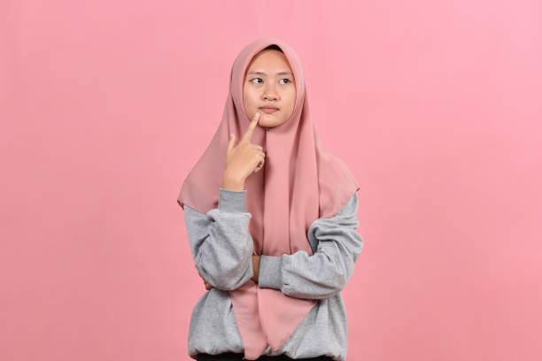 istock Young Asian muslim woman looking at a copy space or thinking an idea 1344426947