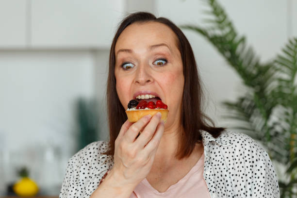istock Brown haired pregnant lady delighted holding tasty cupcake 1344432507