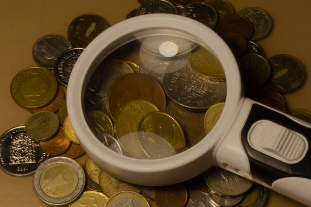 istock working with a collection of coins on the table magnifying glass 1344433656