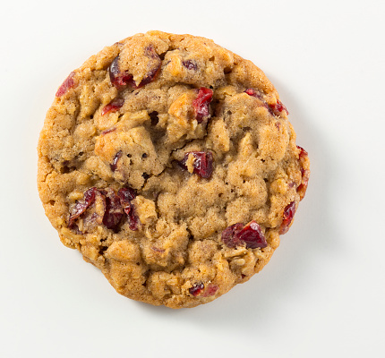 A single cranberry oatmeal cookie on a white background.