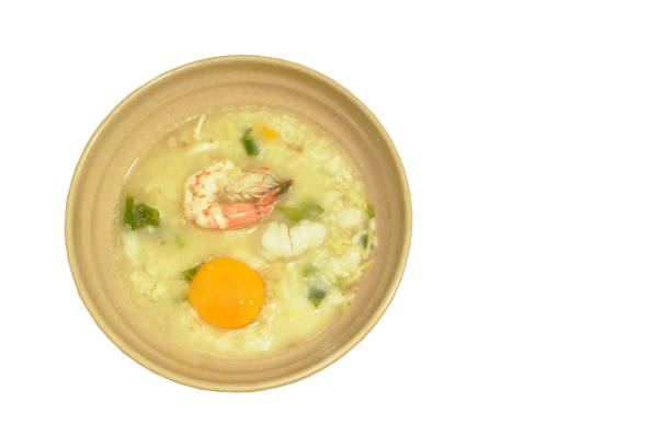 rice porridge shrimp and squid with ginger topping egg yolk on bowl