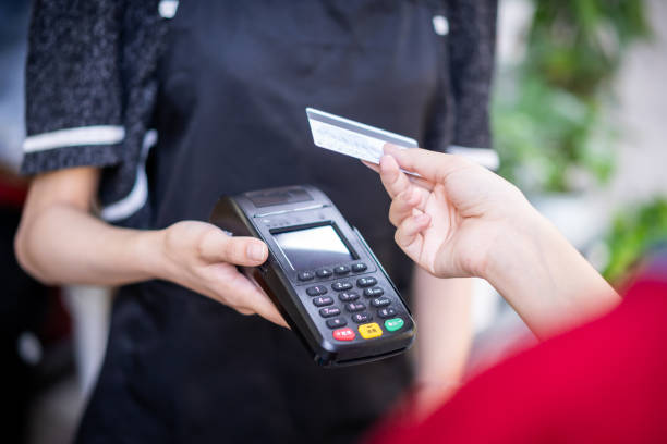 istock A woman uses her phone to make contactless payments 1344435021