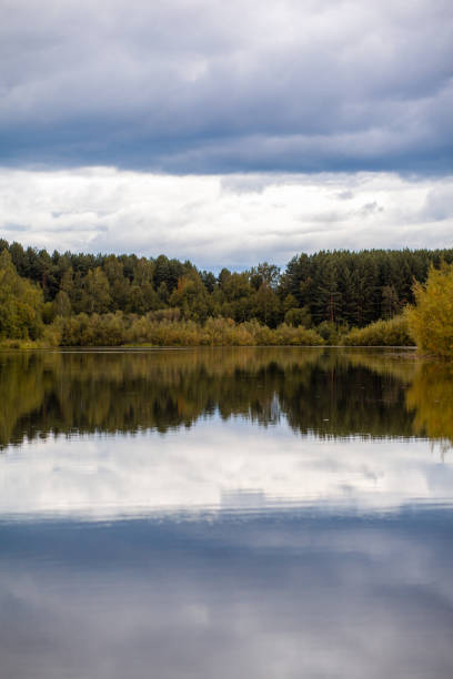 istock Colorful foliage tree reflections in calm pond water on autumn day. 1344436850