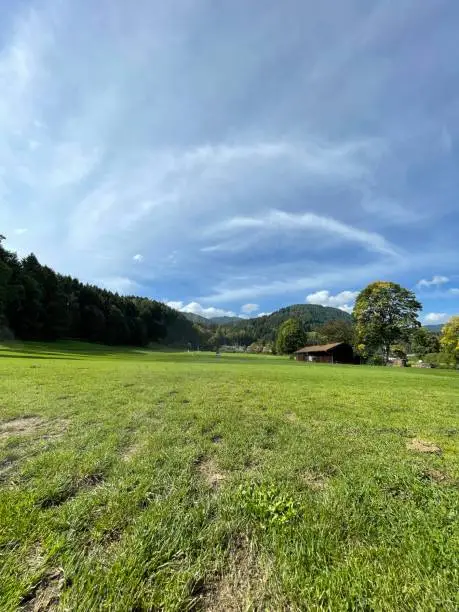 Green meadow, hayloft, mountains, trees, cloud formations in the blue late summer sky, Abwinkl, near Bad Wiessee, Upper Bavaria 
 
More