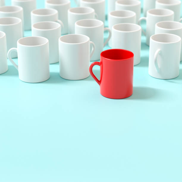 Standing out from the grey mass. Leadership concept. One red mug in front of white mugs. stock photo