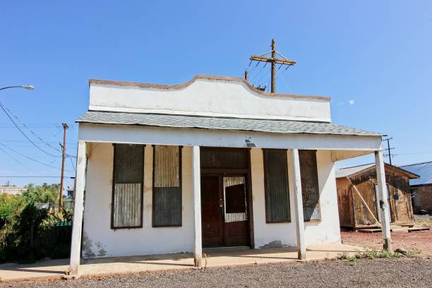 istock Boarded Up Windows On White Stucco Abandoned Building 1344441390