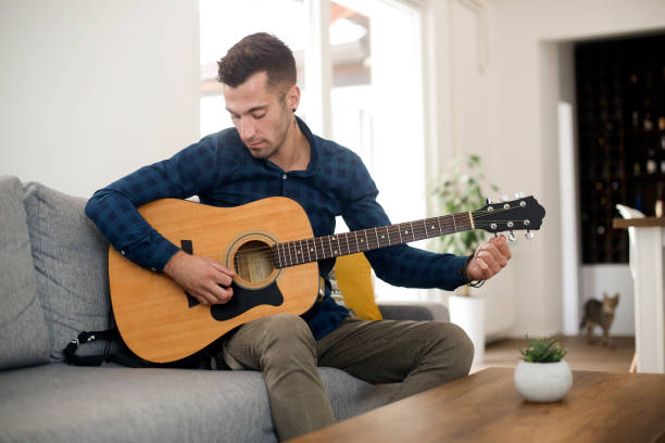 istock Young man tuning his guitar 1344445238