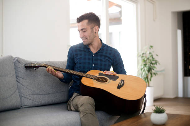 istock Young man polishing his guitar 1344445248