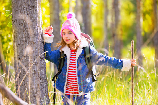 istock Hiking kid girl with backpack in autum poplar forest 1344445488