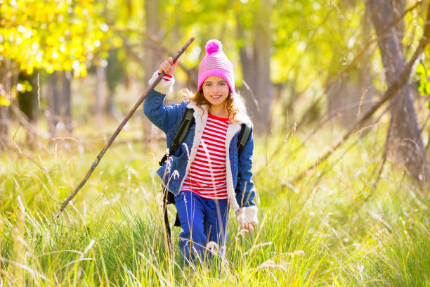 istock Hiking kid girl with backpack in autum poplar forest 1344445496