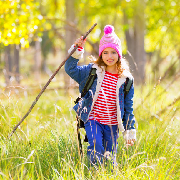 istock Hiking kid girl with backpack in autum poplar forest 1344445508