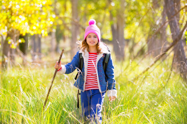 istock Hiking kid girl with backpack in autum poplar forest 1344445514