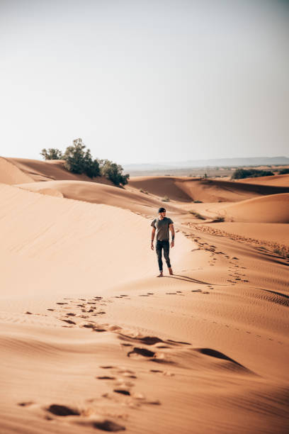 istock sexy man walking on the sand 1344446261