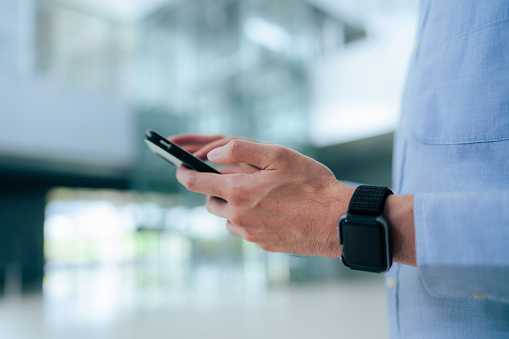 Business Asian male checking time on smart Phone