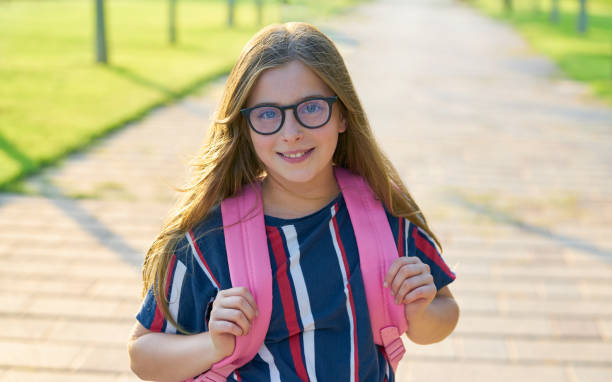 istock Blond kid student girl with glasses in park 1344447407