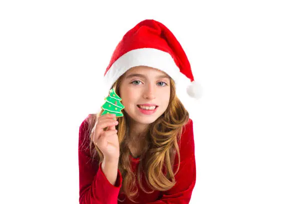 Christmas kid girl holding Xmas tree cookie isolated on white background