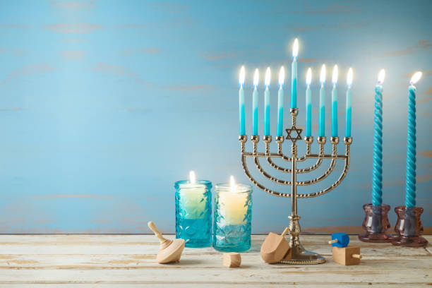 concepto de fiesta judía hanukkah con menorá, velas y dreidel sobre mesa de madera. fondo para tarjeta de felicitación o banner - menorah fotografías e imágenes de stock