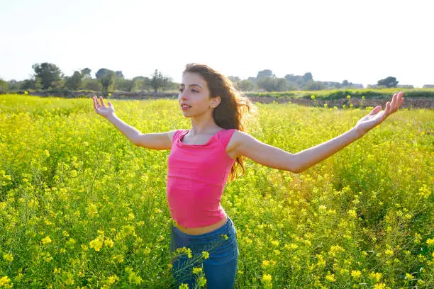 open arms happy teen girl in spring meadow brunette