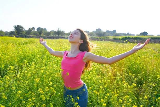 open arms happy teen girl in spring meadow brunette
