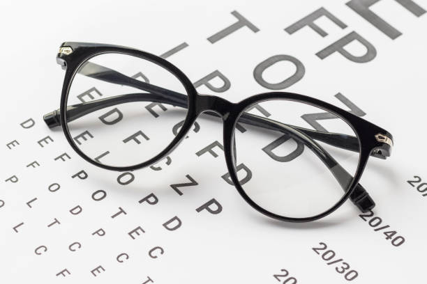 istock Eyeglasses with black frame on visual test chart isolated on white. Eyesight, healthcare and medicine concept. 1344450235